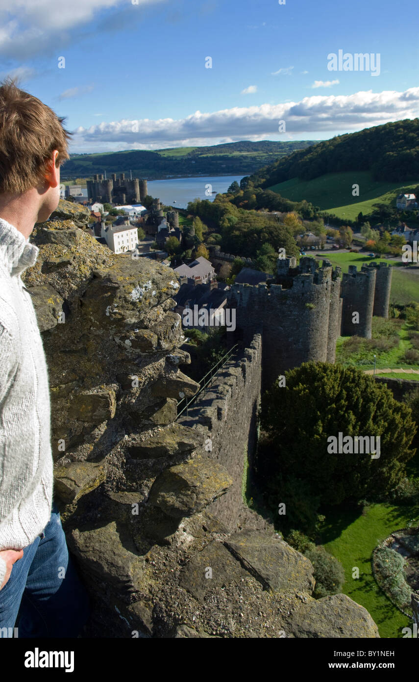 UK, Nord Wales; Conwy. Ein Besucher genießt die Aussicht vom befestigten Stadtmauer mit der Stadt, Burg und Conwy River Stockfoto