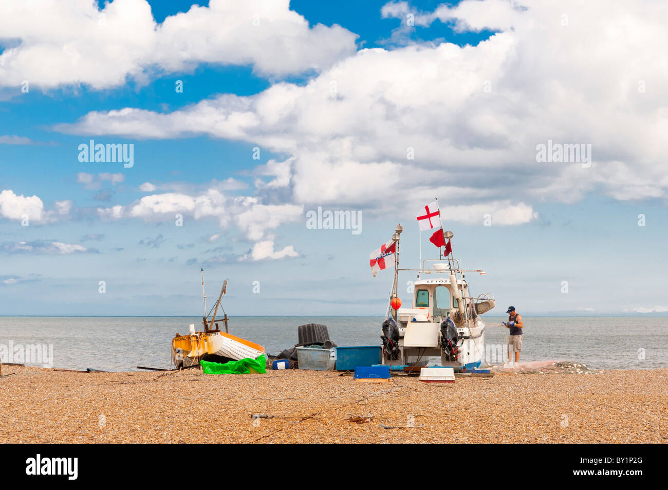 Zwei Fischerboote und ein Fischer am Strand von Aldeburgh, Suffolk, England, Großbritannien, Uk Stockfoto