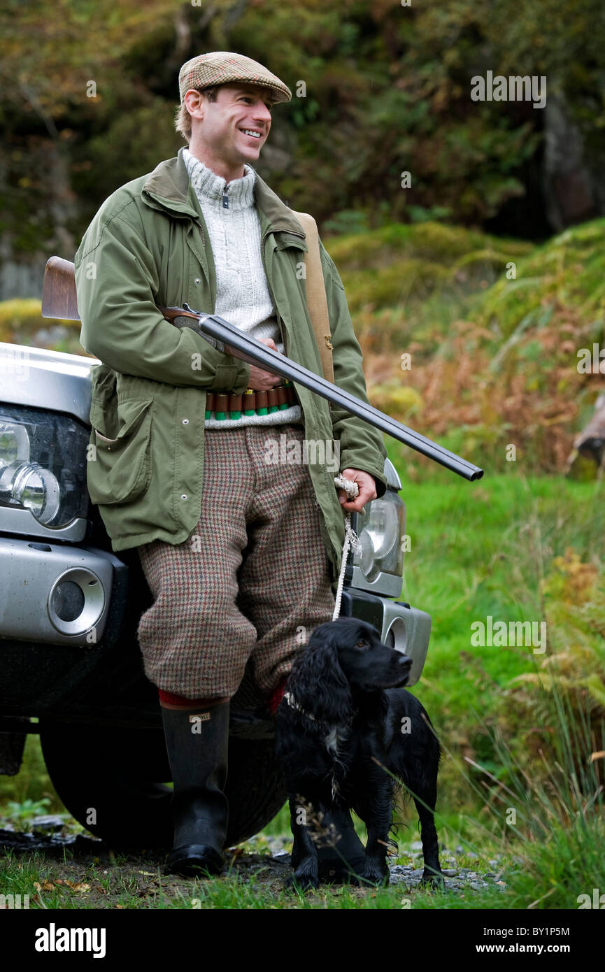 North Wales, Snowdonia; Gilar Farm. Ein Mann entspannt schiefen gegen seinen Landrover, während auf die Jagd. (MR) Stockfoto