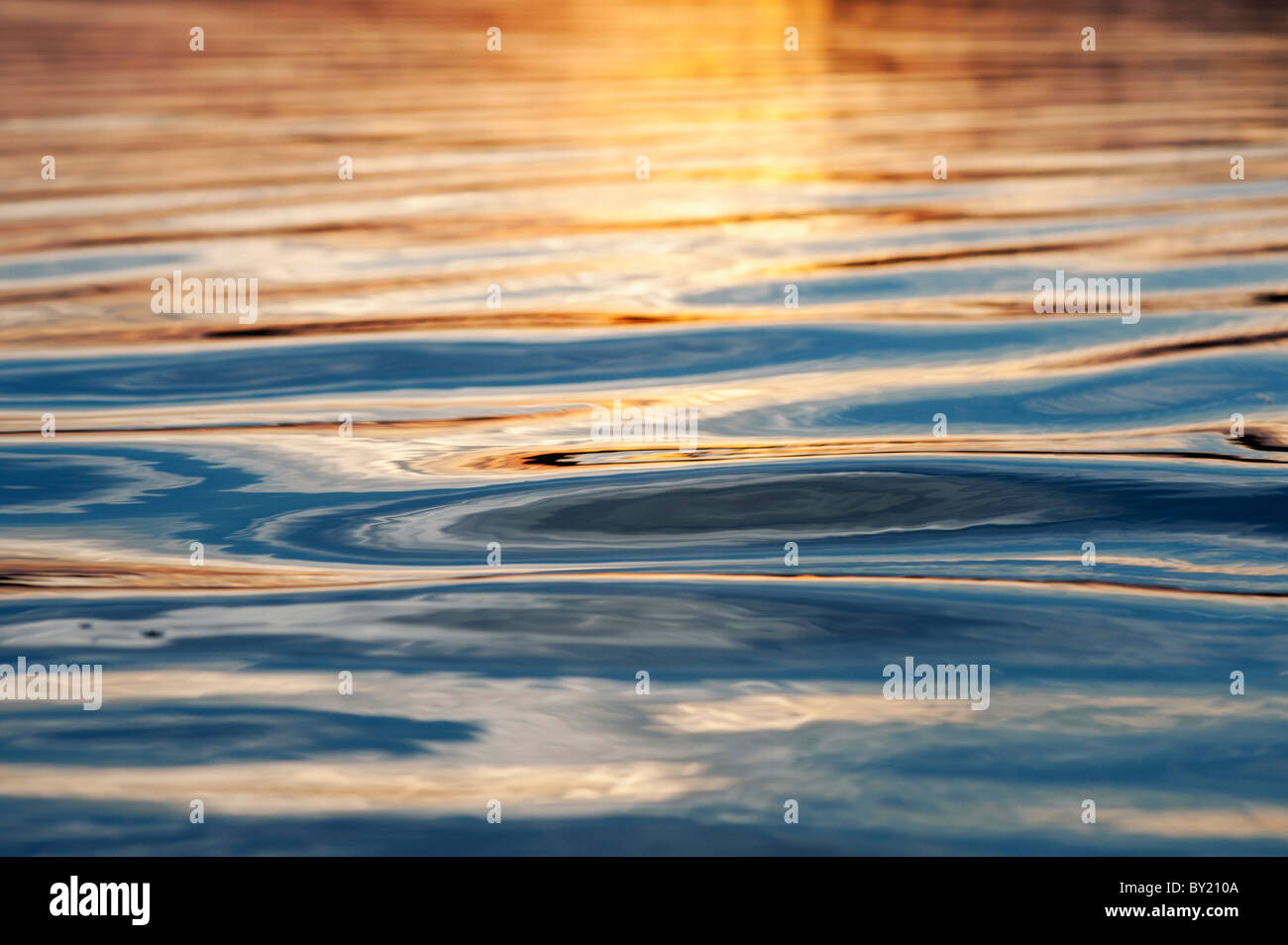Abstrakte goldene Wasser plätschert bei Sonnenuntergang an einem See in Indien Stockfoto