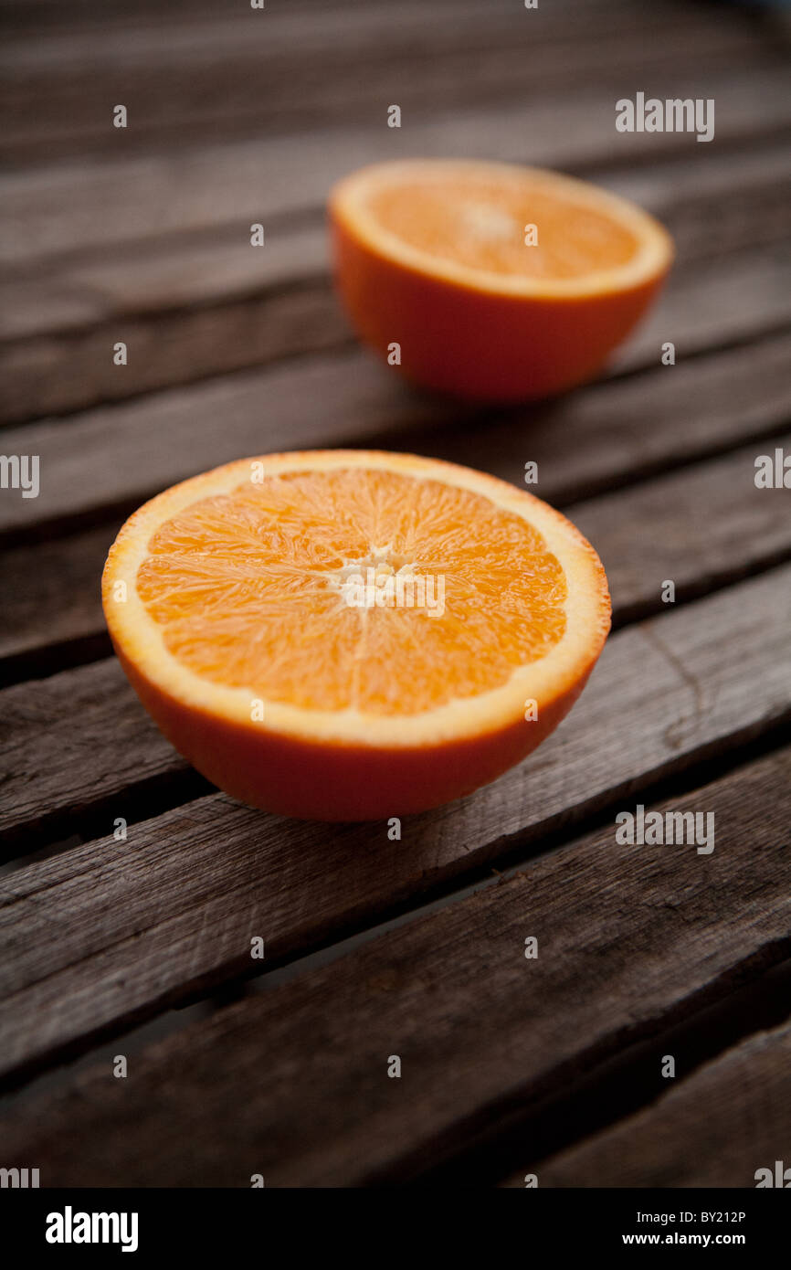 Zwei orange Hälften auf einer hölzernen Oberfläche Stockfoto