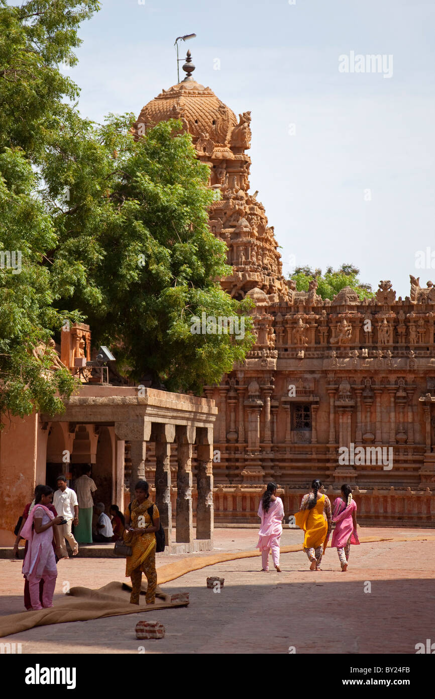 Indien, Thanjavur. Bunte Saris Kontrast mit kunstvollen Schnitzereien des Brihadeeswarar Tempels. Stockfoto