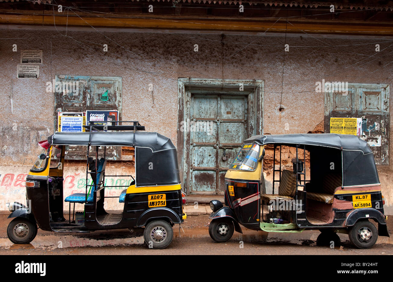 Indien, Cochin. Tuk-Tuks parkte vor einer alten Mauer in Cochin. Stockfoto