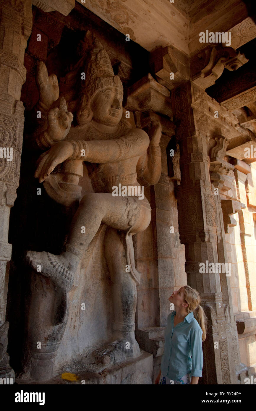 Indien, Thanjavur. Ein Tourist staunt über die Größe des Schnitzwerks einer Gottheit im Tempel Brihadeeswarar. MR. Stockfoto