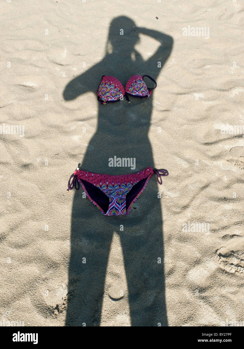Ein Schatten einer Frau auf dem Sand mit einem Bikini platziert  Stockfotografie - Alamy