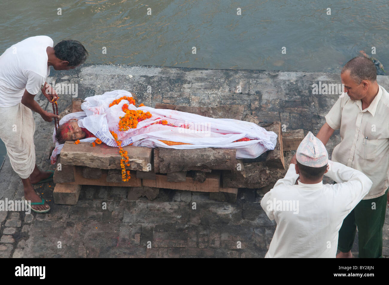 letzte Riten bei einer Einäscherung Beerdigung am Fluss Bagmati im Pashupatinath Tempel in Kathmandu, Nepal Stockfoto