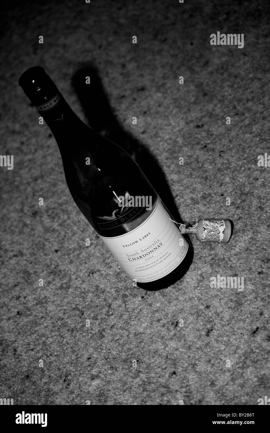Eine Flasche Wein und ein Partyspaß in schwarz / weiß Stockfoto