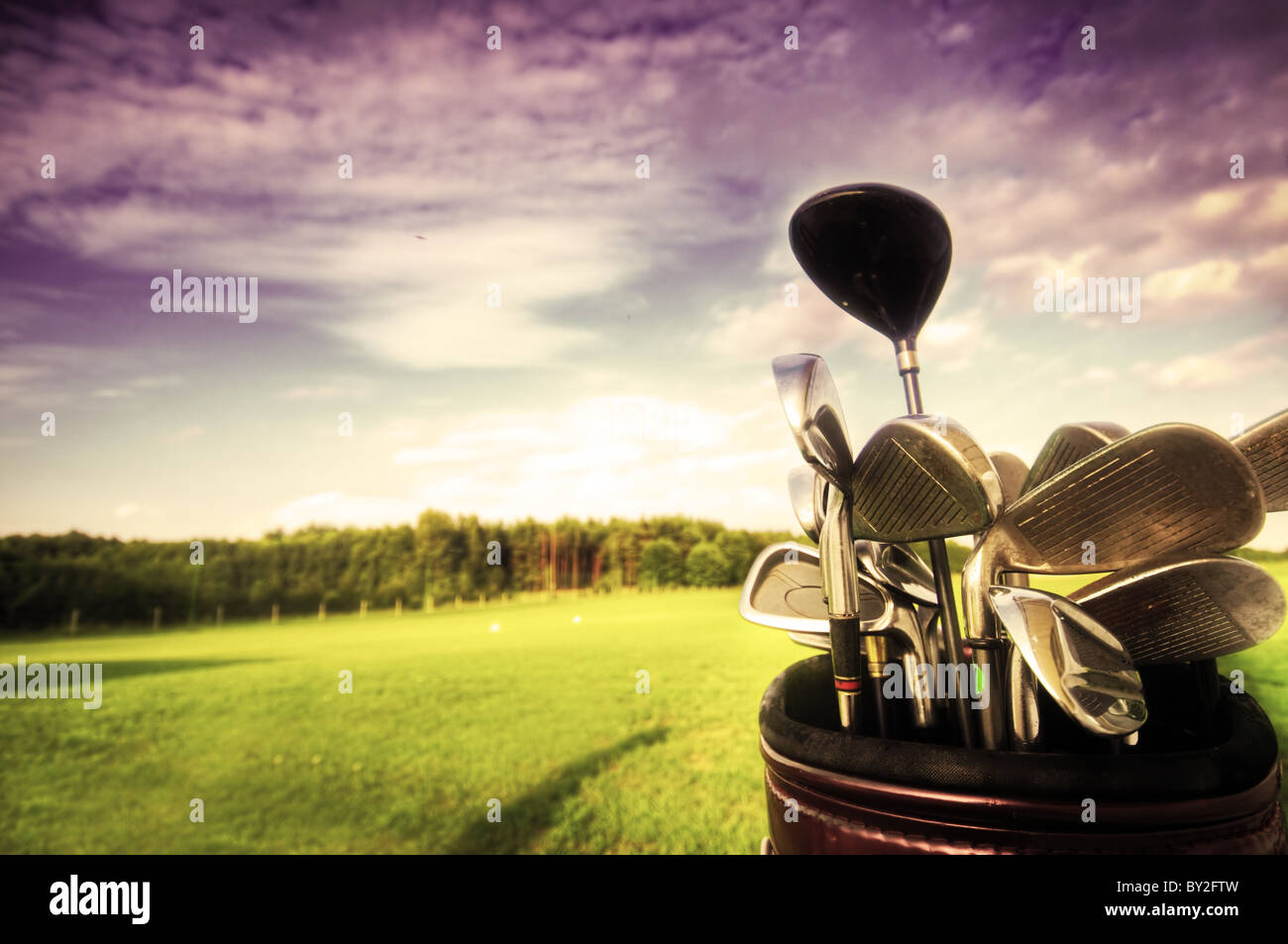 Profi-Golf-Ausrüstung auf dem Golfplatz bei Sonnenuntergang. Stockfoto