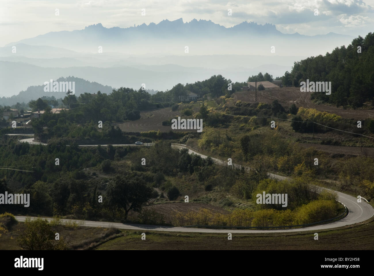 Eine kurvenreiche Straße in Katalonien, Spanien führt in die Montserrat Berge am Horizont. Stockfoto