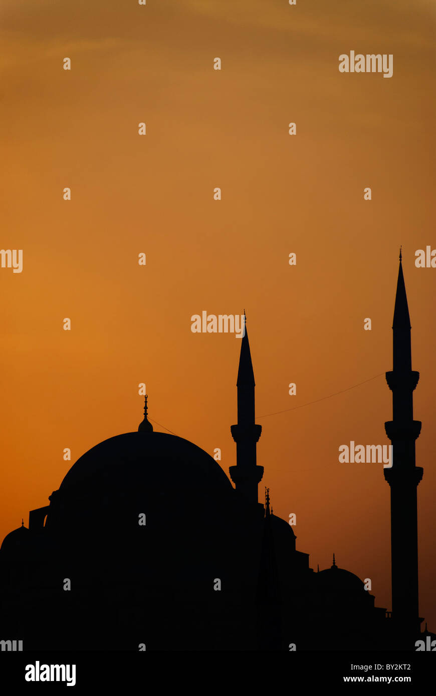 Süleymaniye Moschee Silhouette Istanbul Türkei // ISTANBUL, Türkei — Silhouette der Süleymaniye Camii (Süleymaniye Moschee) in Istanbul, Türkei. Die großartige Silhouette der Moschee ist dramatisch vor einem leuchtenden orangefarbenen Himmel geworfen, wahrscheinlich bei Sonnenauf- oder -Untergang. Stockfoto