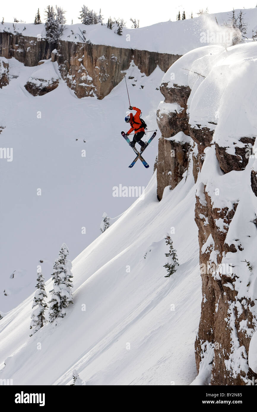 Ein männlicher Skifahrer springt von einer Klippe in Wyoming Backcountry. Stockfoto