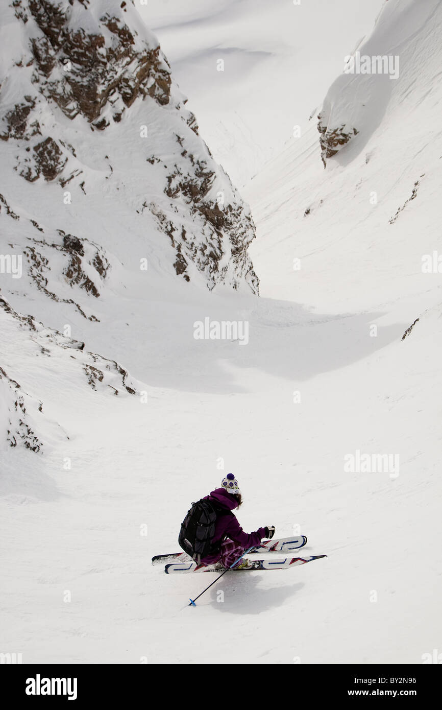 Eine Skifahrerin fällt in der 60 Grad einmal befindet sich genug Couloir im Jackson Hole Mountain Resort Hinterland, Wyom Stockfoto