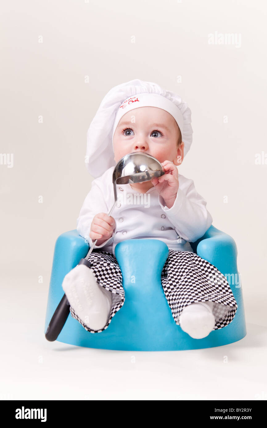 Baby-Koch mit einer Suppenkelle Cooks Outfit tragen. Stockfoto