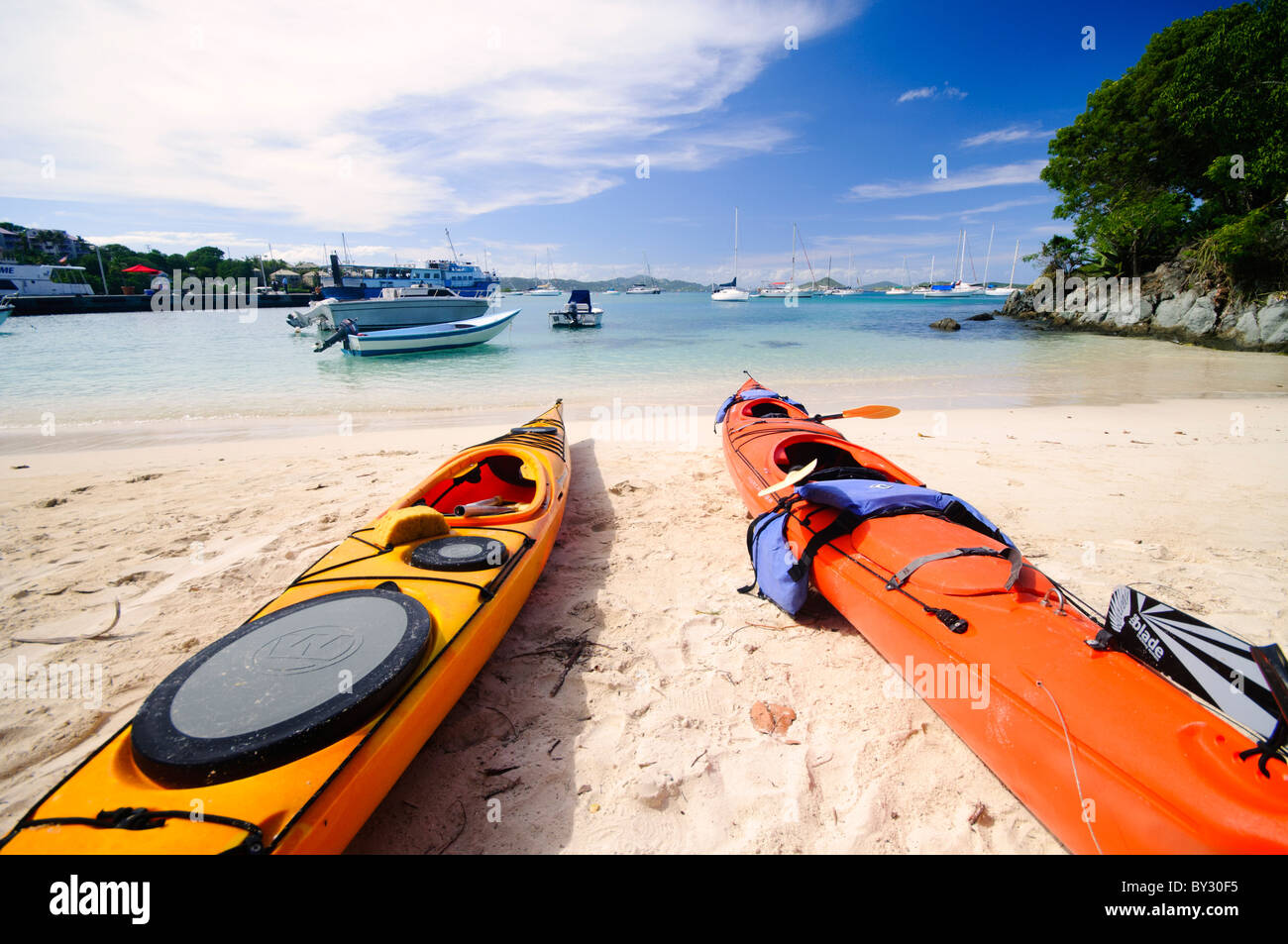 CRUZ BAY, St. John, US Jungferninseln – farbenfrohe Kajaks säumen den Strand von Christian Cove in Cruz Bay, der wichtigsten Stadt und dem Einreisehafen auf St. John auf den US Jungferninseln. Diese lebendigen Wasserfahrzeuge bieten Besuchern die Möglichkeit, die Küste zu erkunden und sich auf Wasserbasis zu entspannen und die beliebten Outdoor-Aktivitäten auf dieser karibischen Insel zu präsentieren. Stockfoto