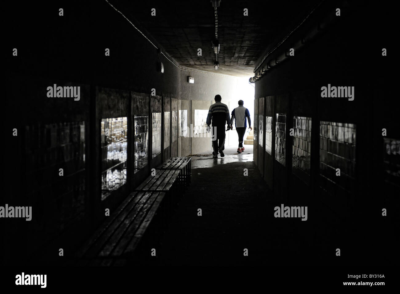 Zwei Männer gehen in dunklen Tunnel Silhouette Stockfoto