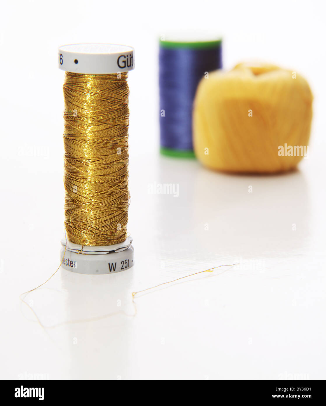 Gold, gelb und blau synthetische Garn auf weißem Hintergrund Stockfoto
