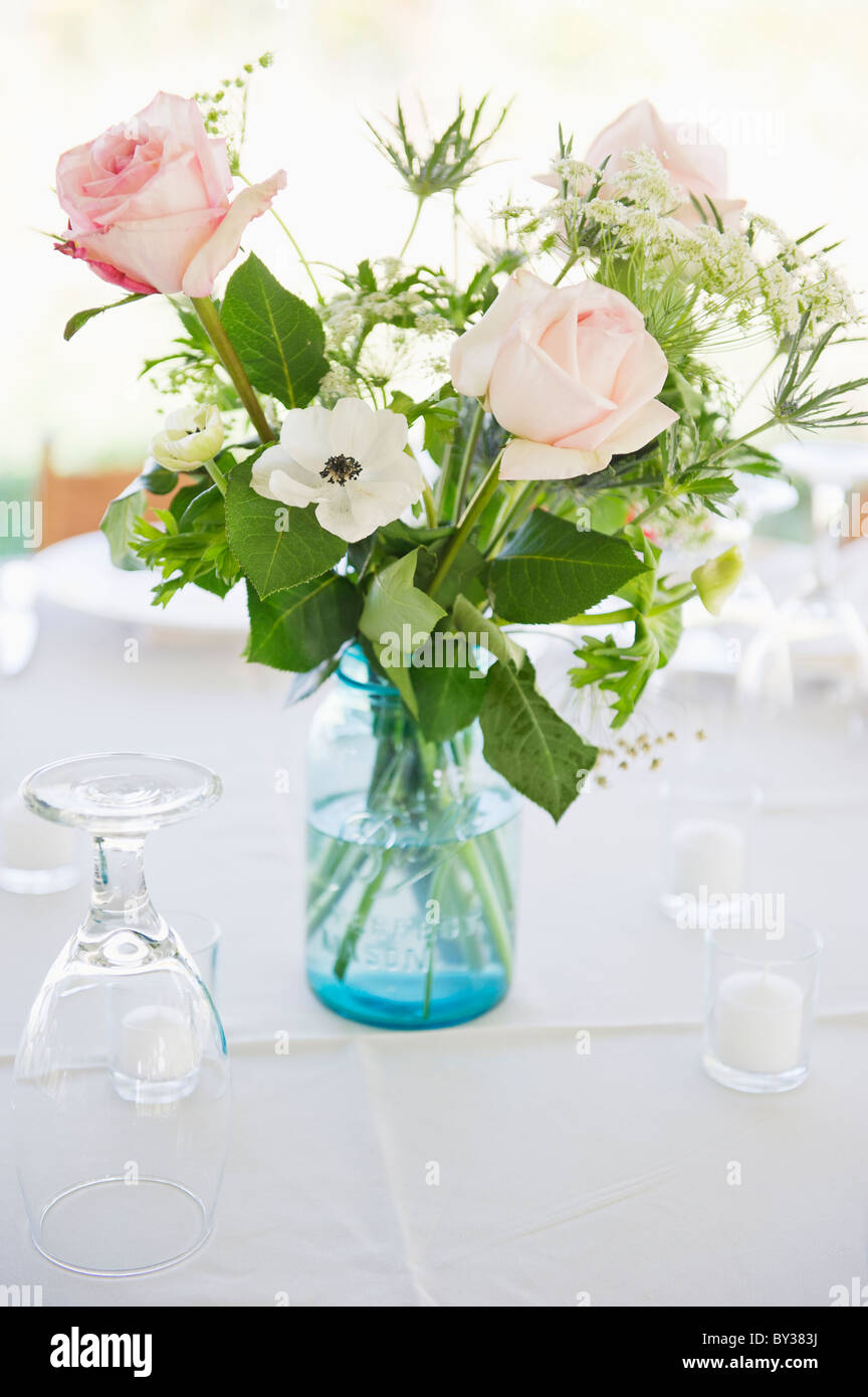 Vase mit Rosen auf Set Tisch mit Brille Stockfoto