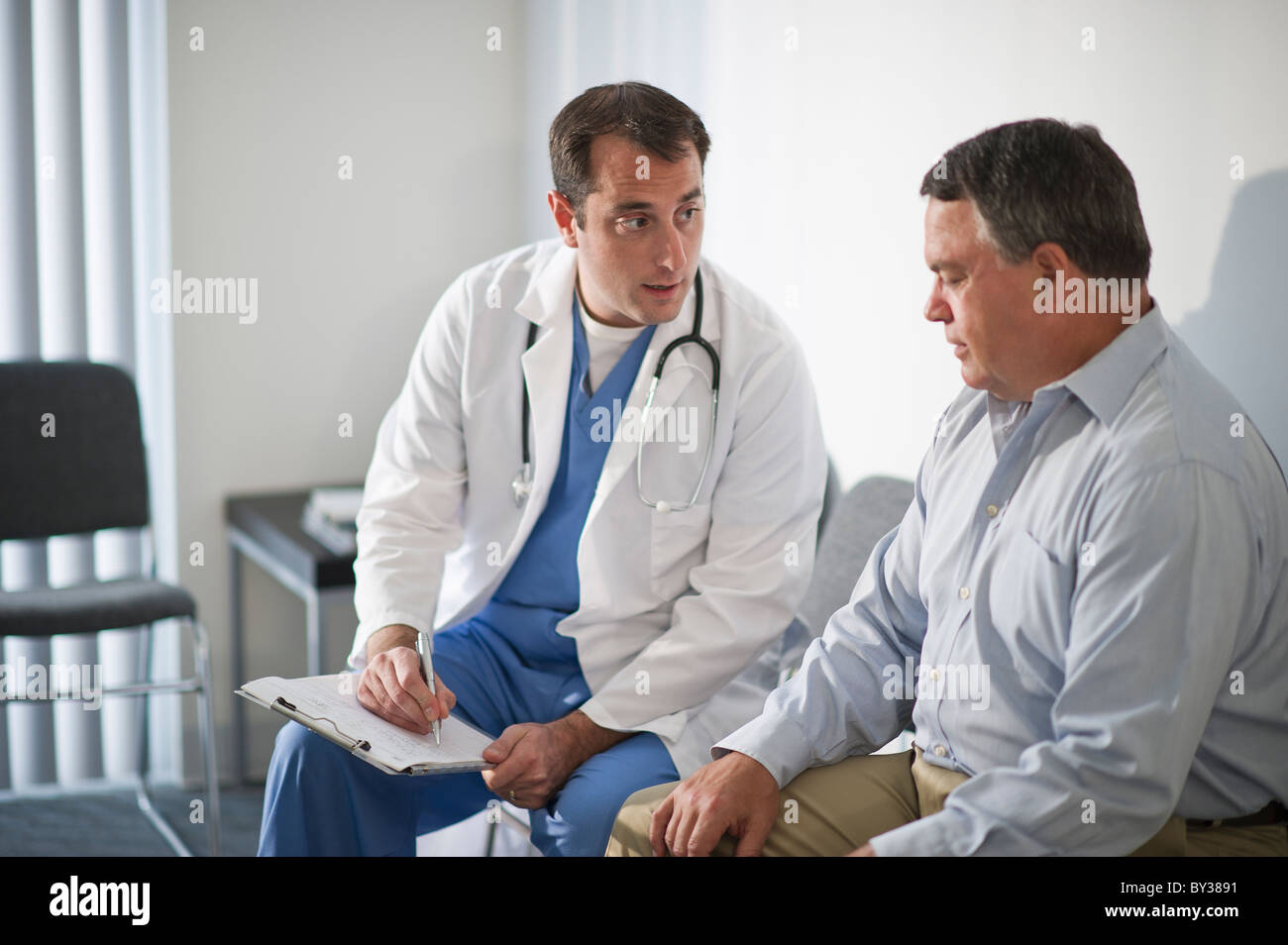 USA, New Jersey, Jersey City, Arzt medizinische Ergebnisse mit männlichen Patienten im Krankenhaus zu diskutieren Stockfoto