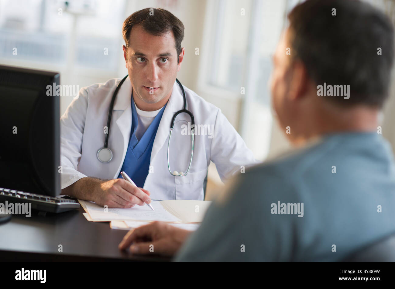 USA, New Jersey, Jersey City, Arzt medizinische Ergebnisse mit männlichen Patienten im Büro zu diskutieren Stockfoto