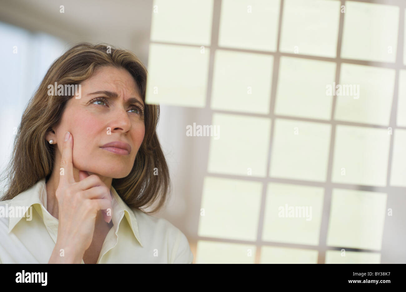 USA, New Jersey, Jersey City, Geschäftsfrau beobachten Klebstoff Hinweise zum Fenster Stockfoto