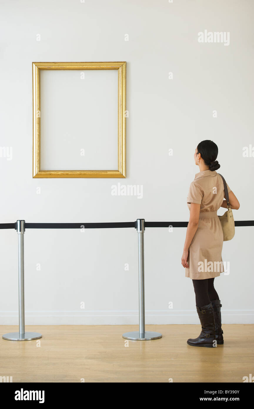 Frau betrachten leere Bilderrahmen in Kunstgalerie Stockfoto