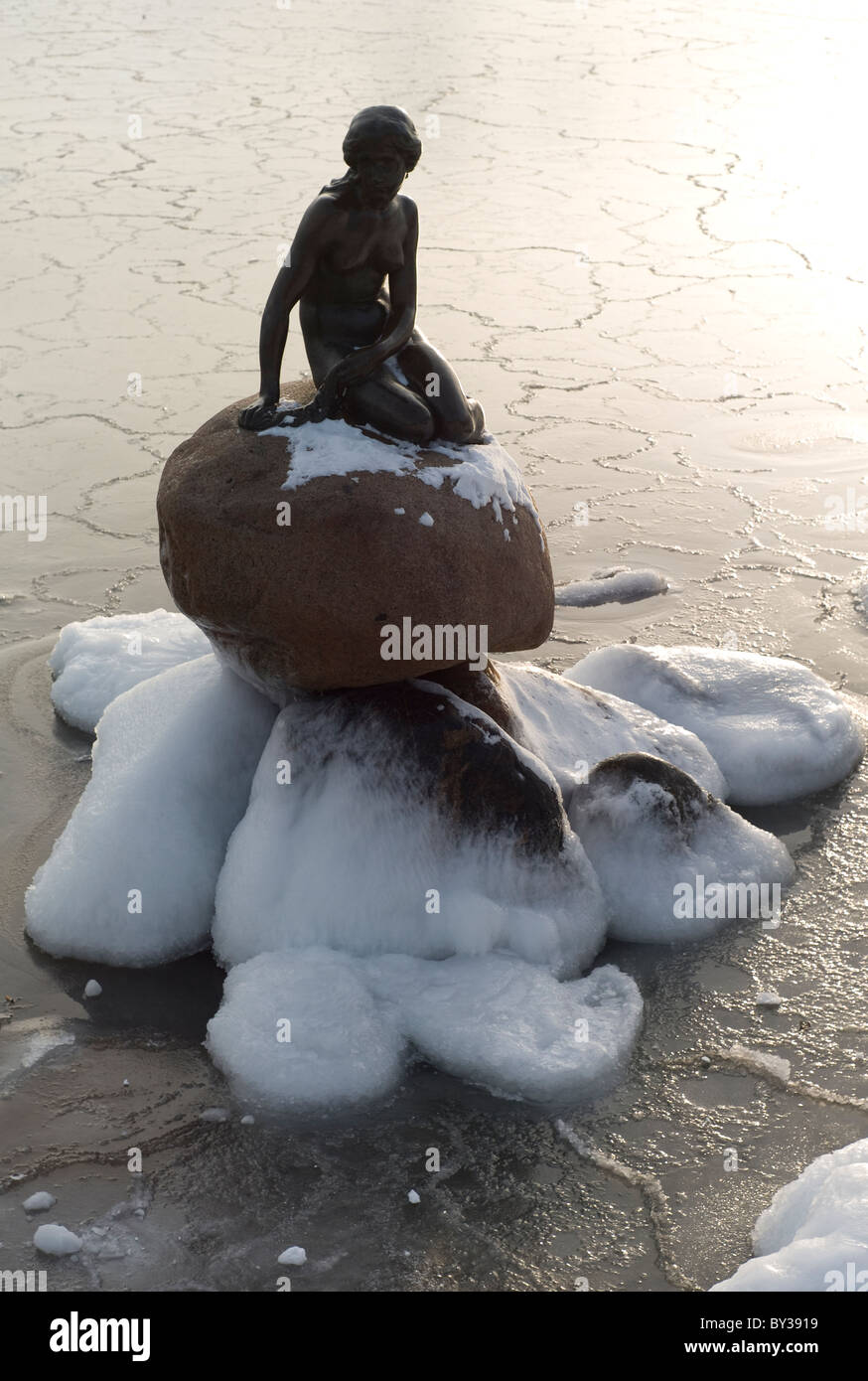 Statue der kleinen Meerjungfrau Bronze in Kopenhagen im Winter, umgeben von Eis und Schnee zur Weihnachtszeit Stockfoto