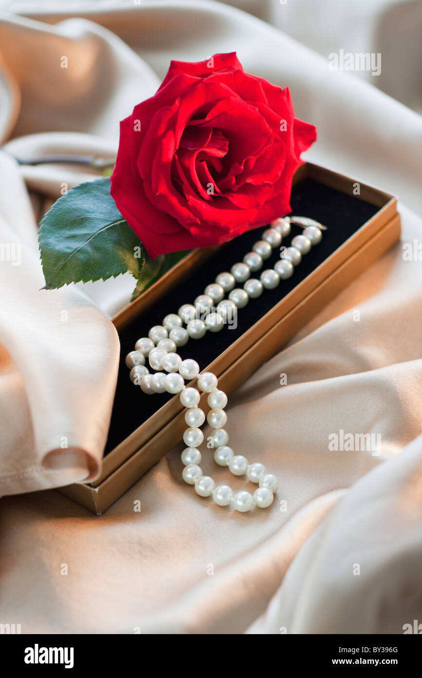 Rose mit Perlenkette auf satin-material Stockfoto
