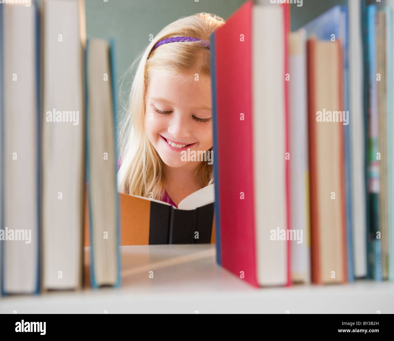 USA, New Jersey, Jersey City, Blick über das Regal zeigen Mädchen (8-9)-Lesebuch Stockfoto