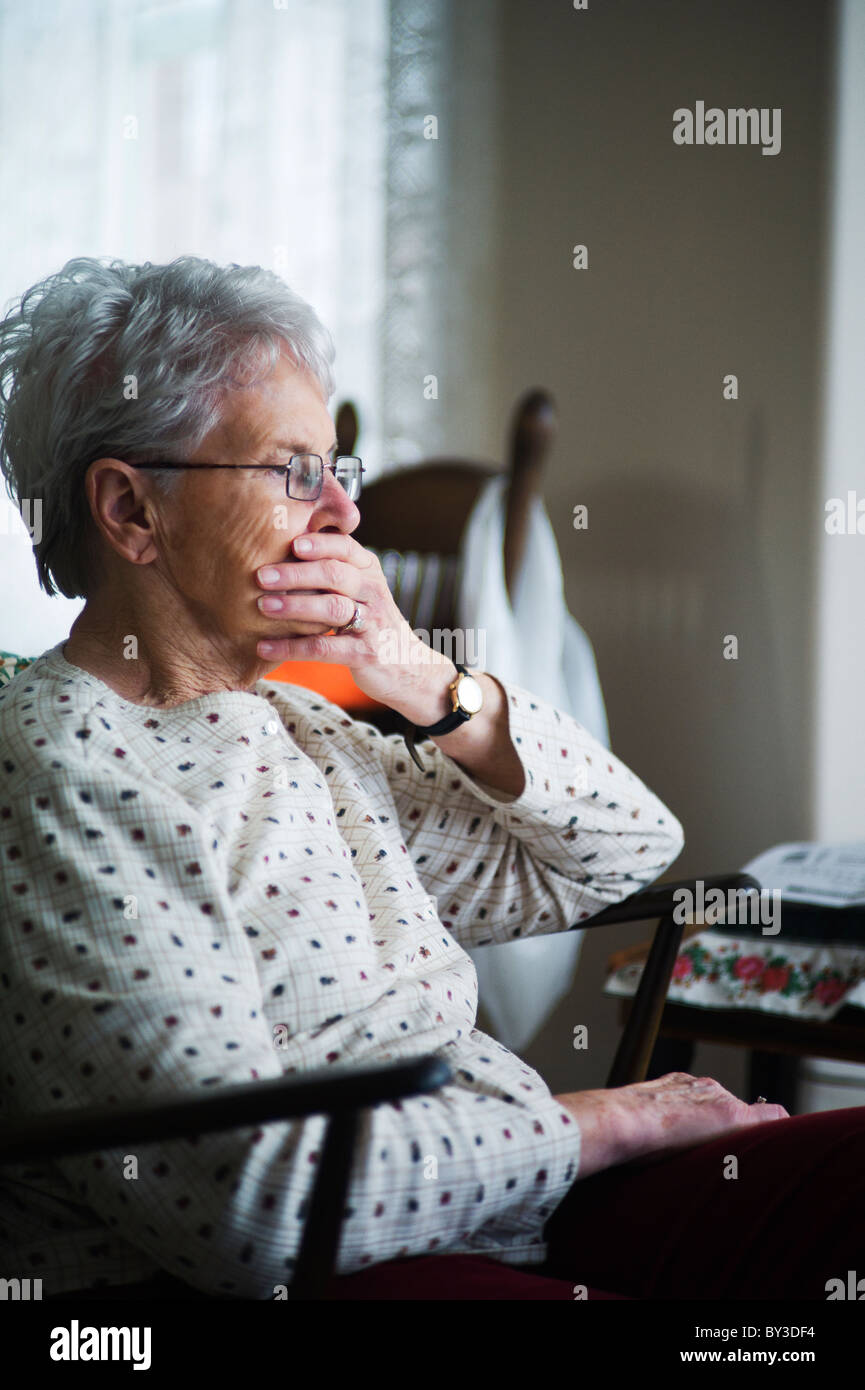 Alte Frau hält die Hand in den Mund. Stockfoto