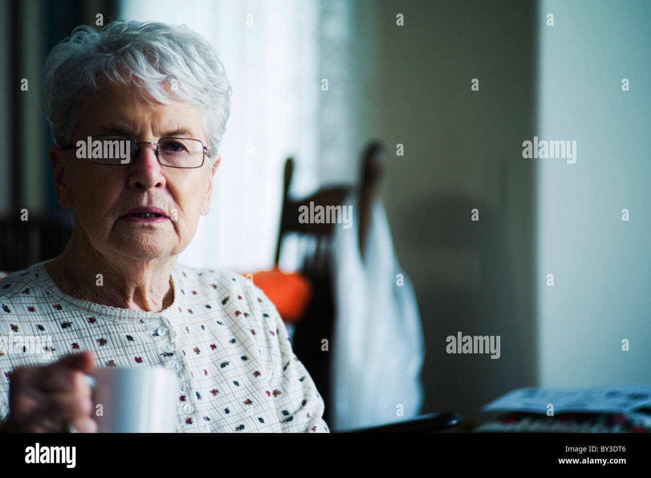 Alte Frau mit Tasse Tee befasst sich mit Fotograf Stockfoto