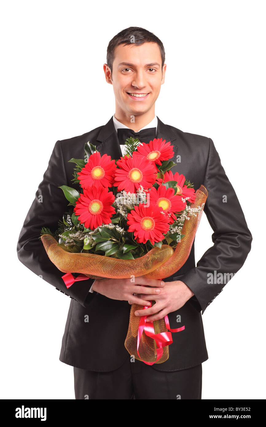 Hübscher Mann trägt schwarzen Anzug und Fliege mit einem Blumenstrauß Stockfoto