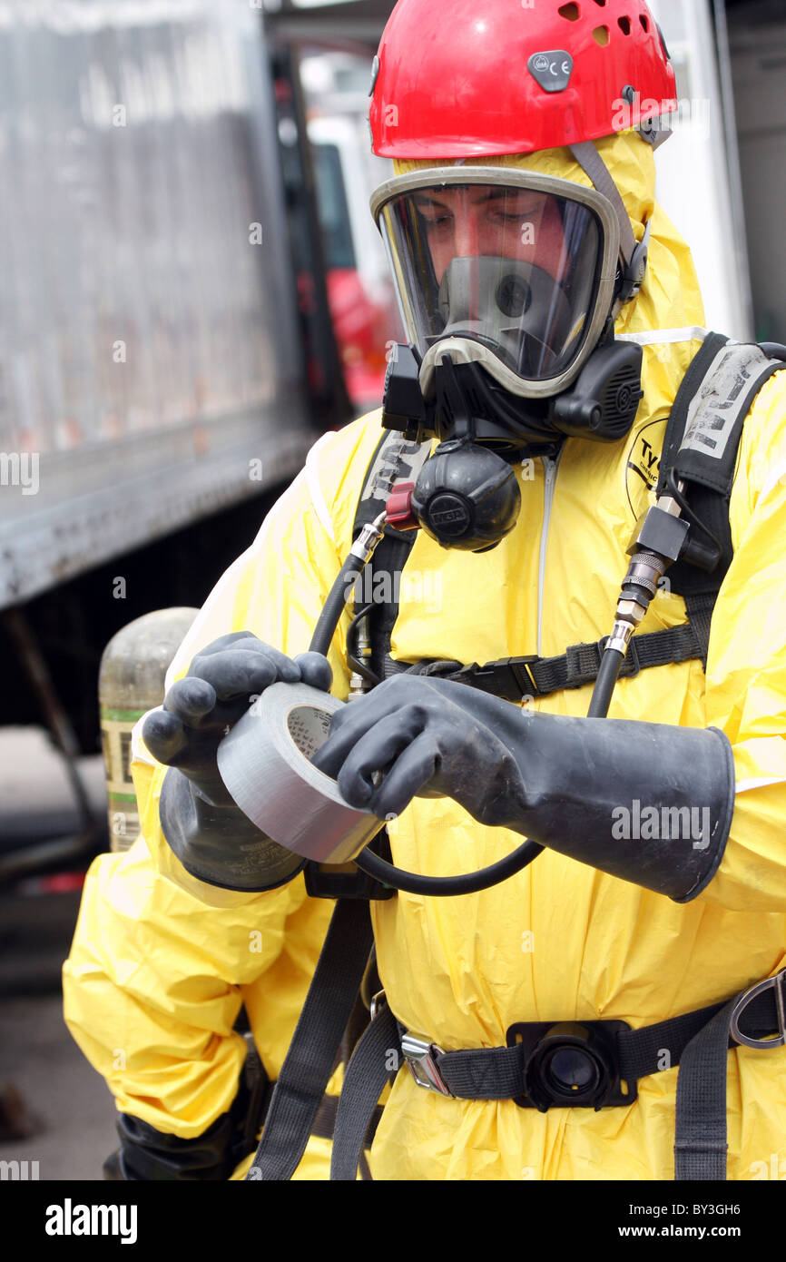 Ein Feuerwehrmann mit Klebeband um den Schutzanzug an eine chemische Haz Mat Spill Vorfall zu sichern Stockfoto