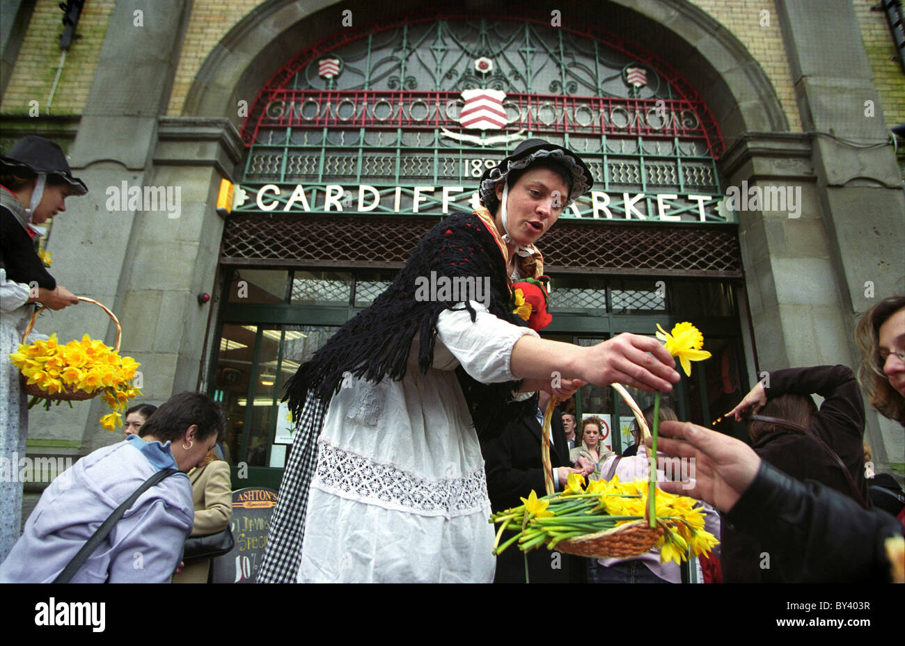 Welsh Damen Ausschank Narzissen in Cardiff Markt am St. Davids Tag. Stockfoto