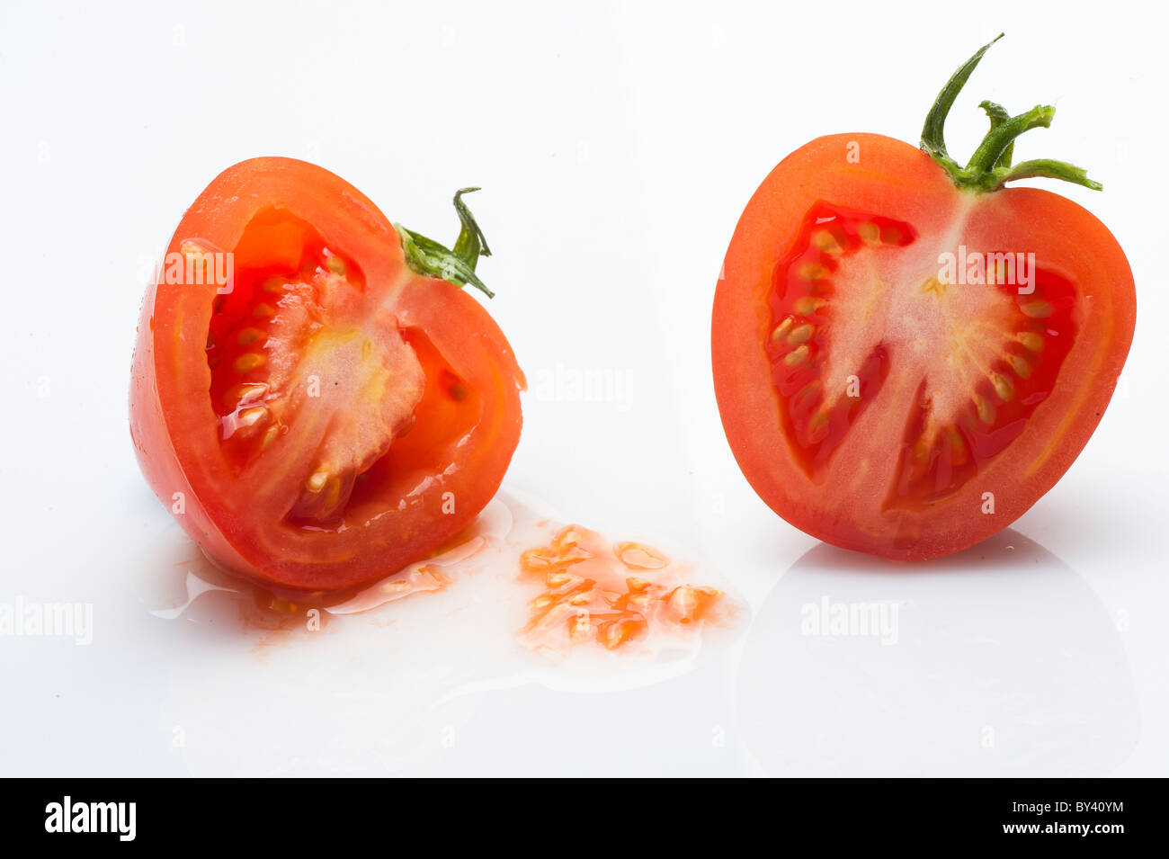 Schneiden von Tomaten auf weißem Hintergrund Stockfoto