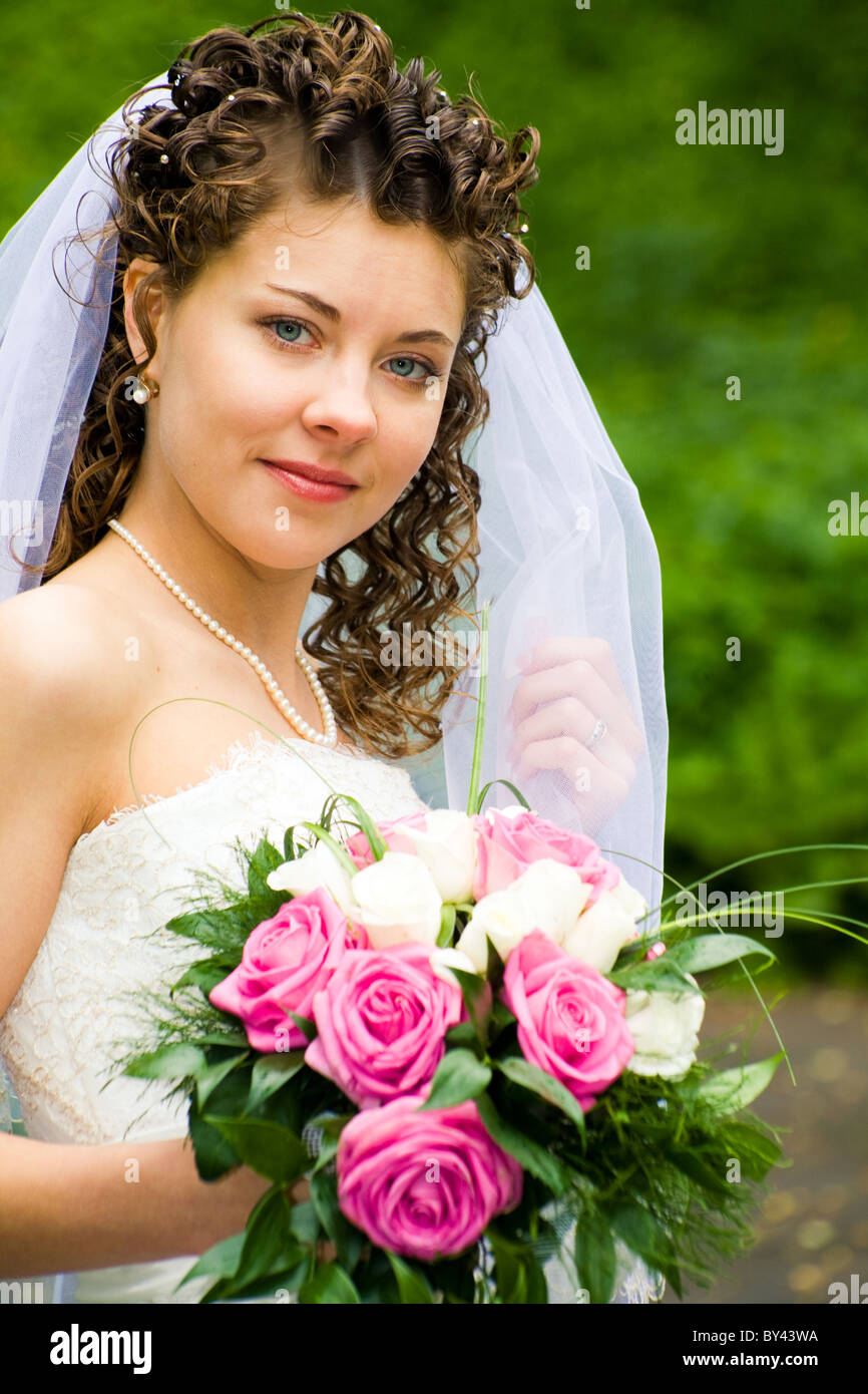 Porträt der schönen Braut mit rosa Blumenstrauß in der hand Blick in die Kamera Stockfoto