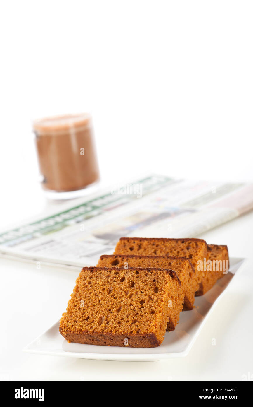 Holländische Frühstück Kuchen, oft gewürzt mit Nelken, Zimt und Muskat. Ein Kaffee und Zeitung im Hintergrund. Stockfoto