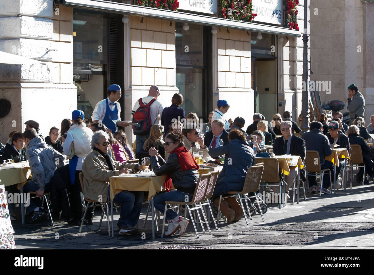 Menschen-Touristen sitzen an touristischen Cafeteria-Bar auf der Straße in einem sonnigen Wintertag Rom Italien Stockfoto