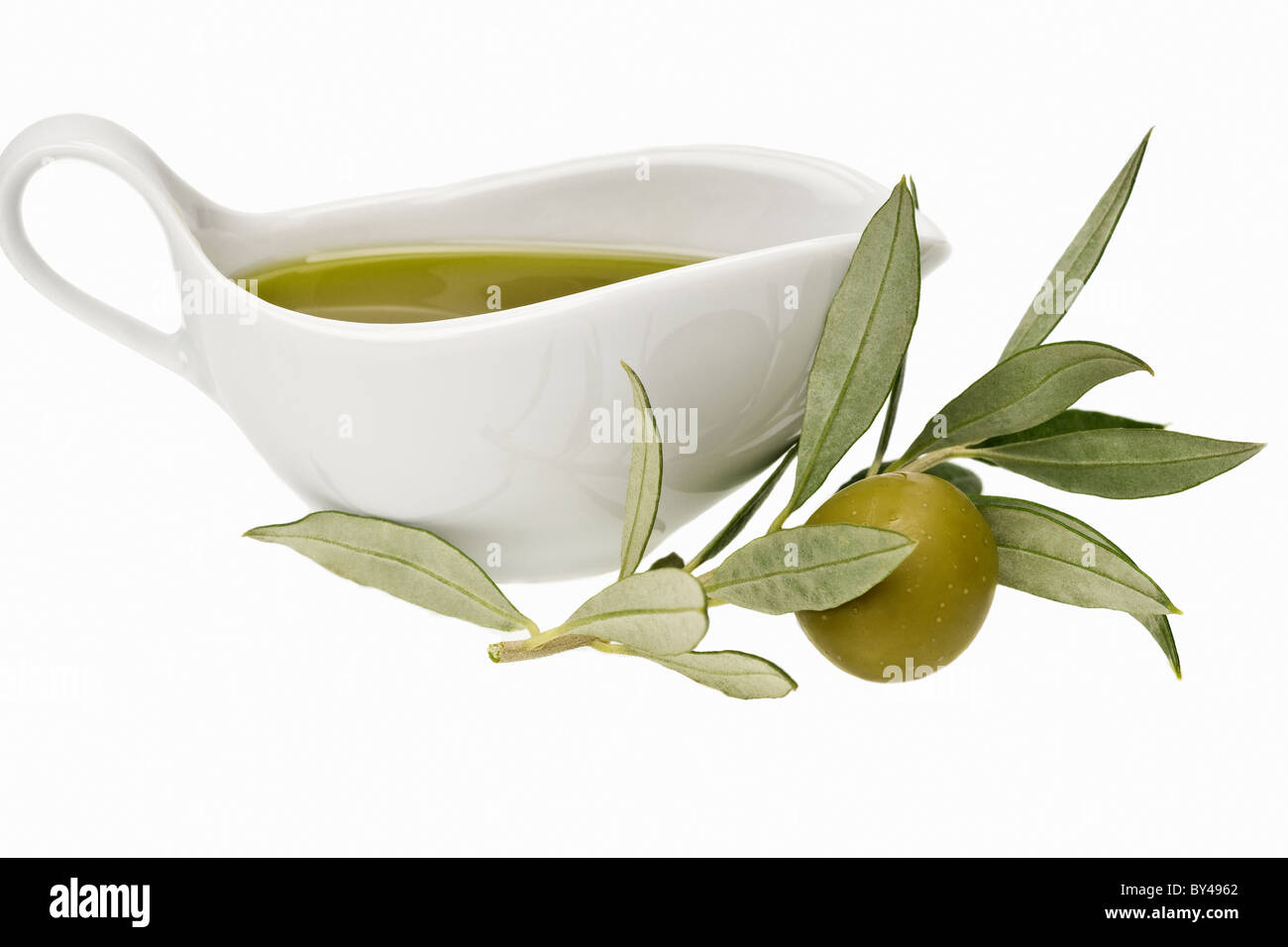 Grüne Oliven auf einem Ast mit frischem Olivenöl extra vergine isoliert auf weiss Stockfoto