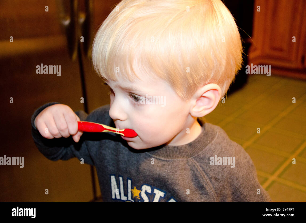 2 bis 3 Jahre alten Jungen mit blonden Haaren, seine Zähne zu putzen Stockfoto