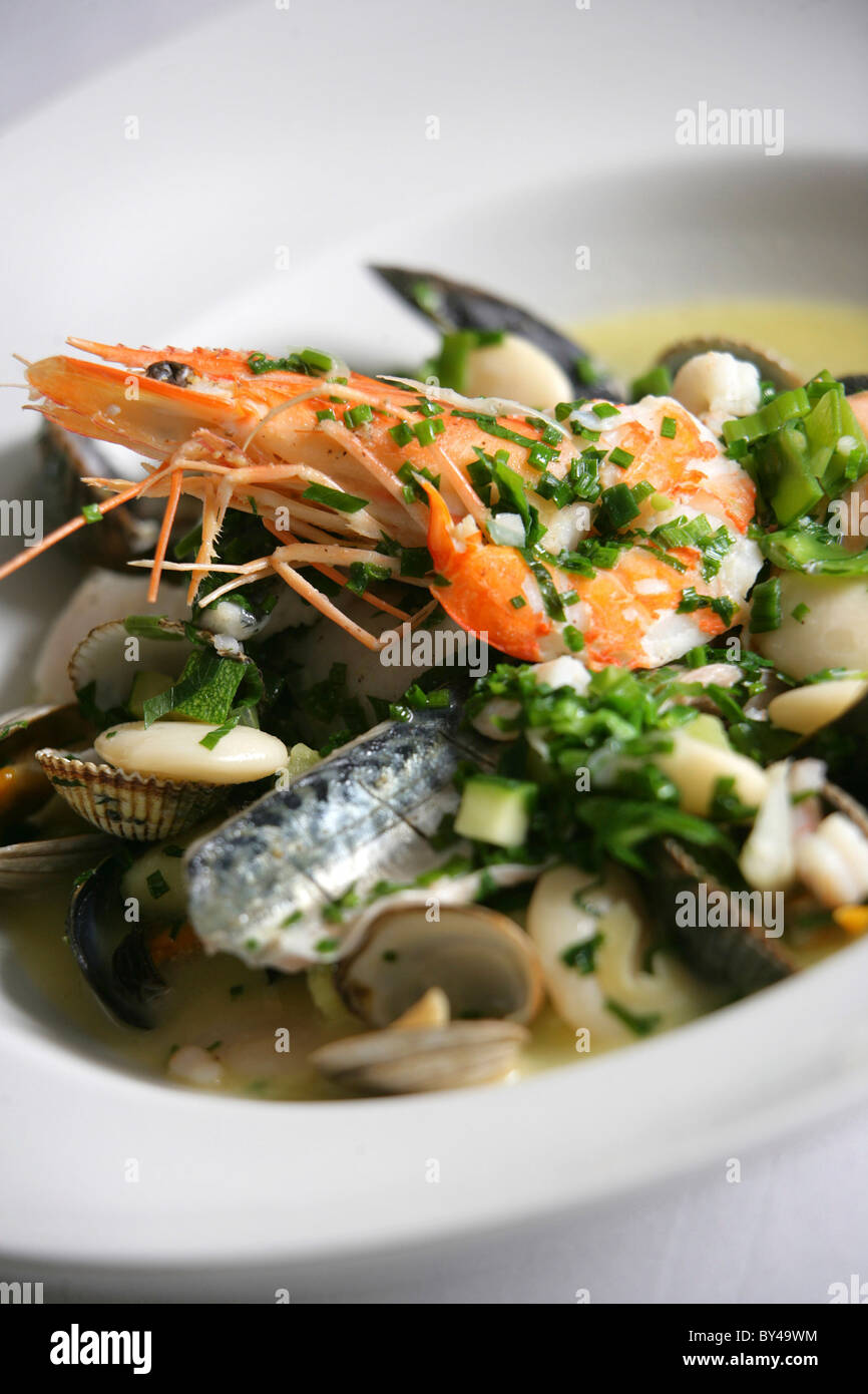 LEICHT POCHIERT AUSWAHL AN FISCH UND MEERESFRÜCHTEN MIT BUTTERBOHNEN UND KRÄUTERN IM NEWPORT RESTAURANT YACHTAUSRÜSTER. Stockfoto