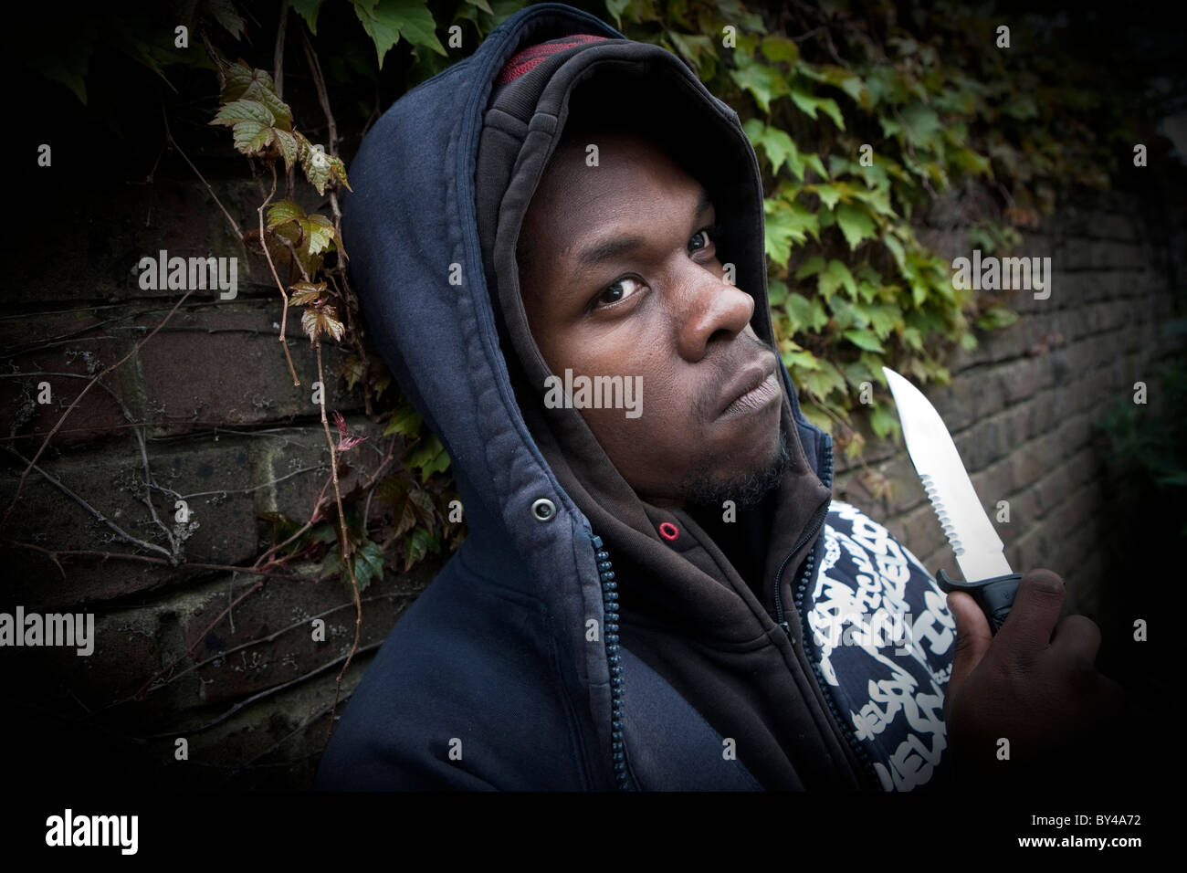 Junge schwarze Jugend-Modell tragen ein hoody mit einem Messer Stockfoto