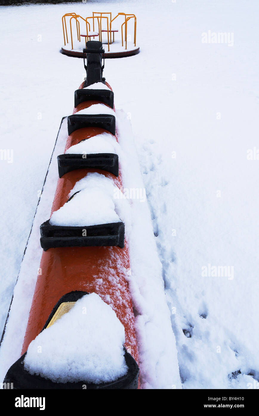 Schaukelpferd und Kreisverkehr ein Kinder Spielplatz unter Schnee Stockfoto