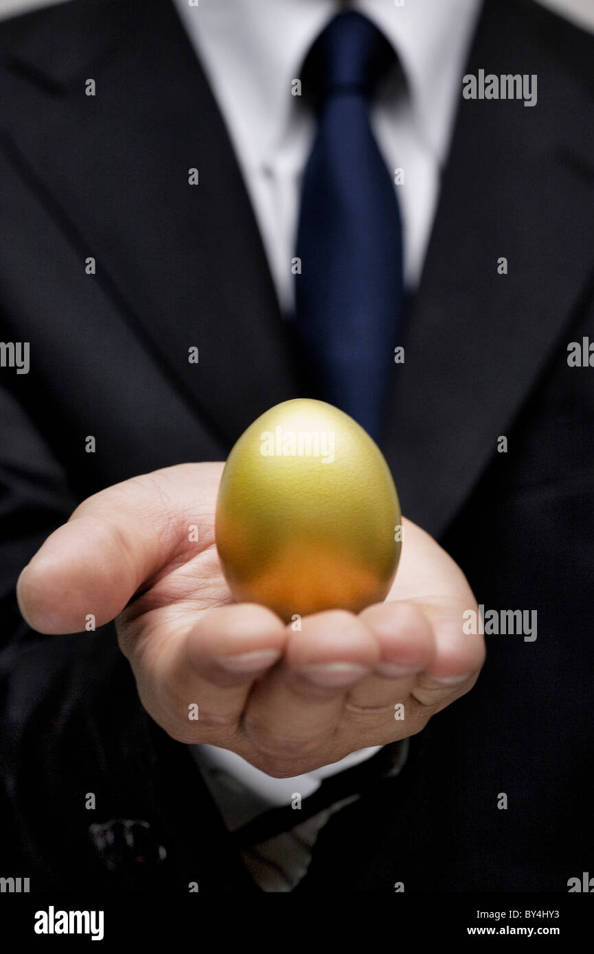 Geschäftsmann mit einem goldenen Ei Stockfoto
