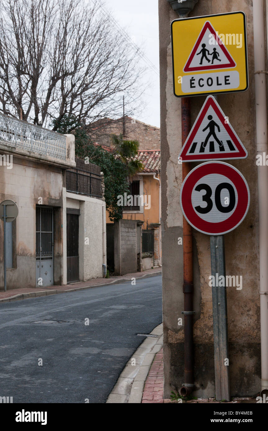 Verkehrszeichen Achtung 30 km/h Höchstgeschwindigkeit, einem Fußgängerüberweg und eine Schule in einem französischen Dorf. Stockfoto