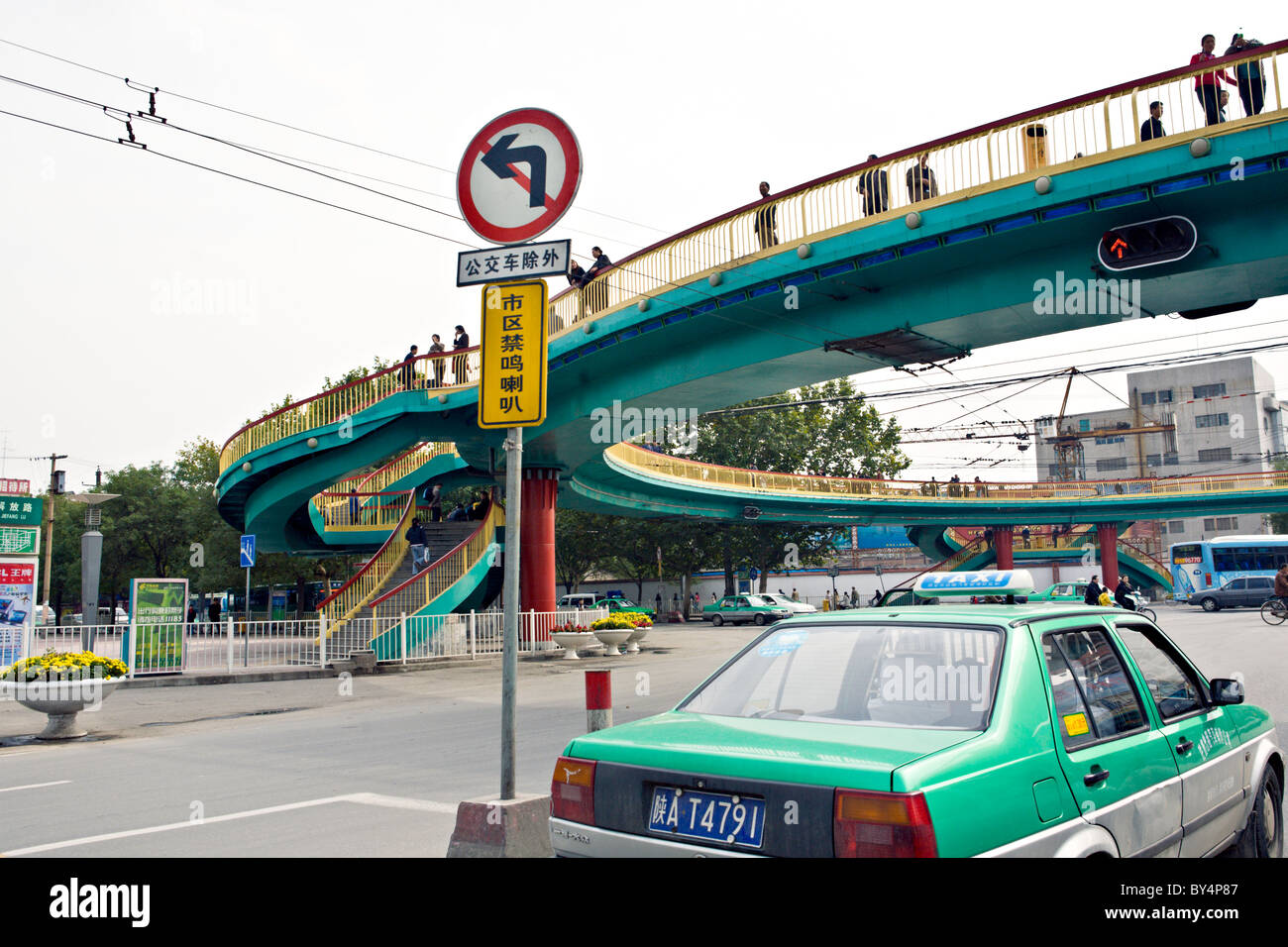 CHINA, Xi ' an: Taxi-Verkehr und Fußgängerbrücke an einer Hauptstraße in Xian, China. Stockfoto