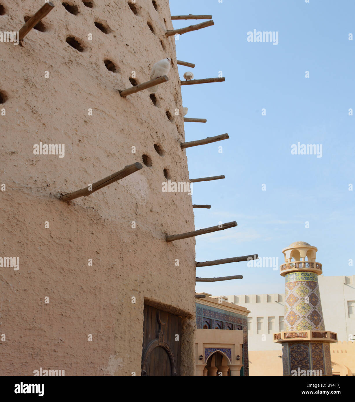 Eine arabische Taubenschlag vor eine reich verzierte Moschee und Minarett in Katara Kulturdorf, Doha, Katar, Arabien Stockfoto