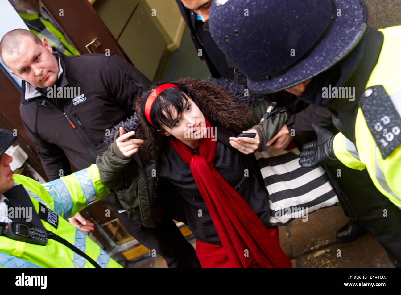 Polizei und privaten Sicherheitsdiensten entfernen ein Demonstrant Ukuncut von Topshop auf der Oxford Street Stockfoto