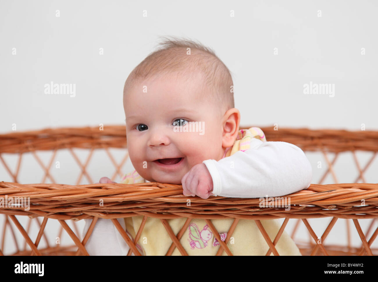 Kleines Mädchen sitzt in einem Korb Stockfoto
