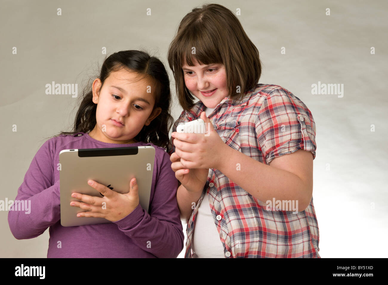 Zwei junge Freunde spielen elektronischer Spiele auf einem Touchscreen pad Stockfoto