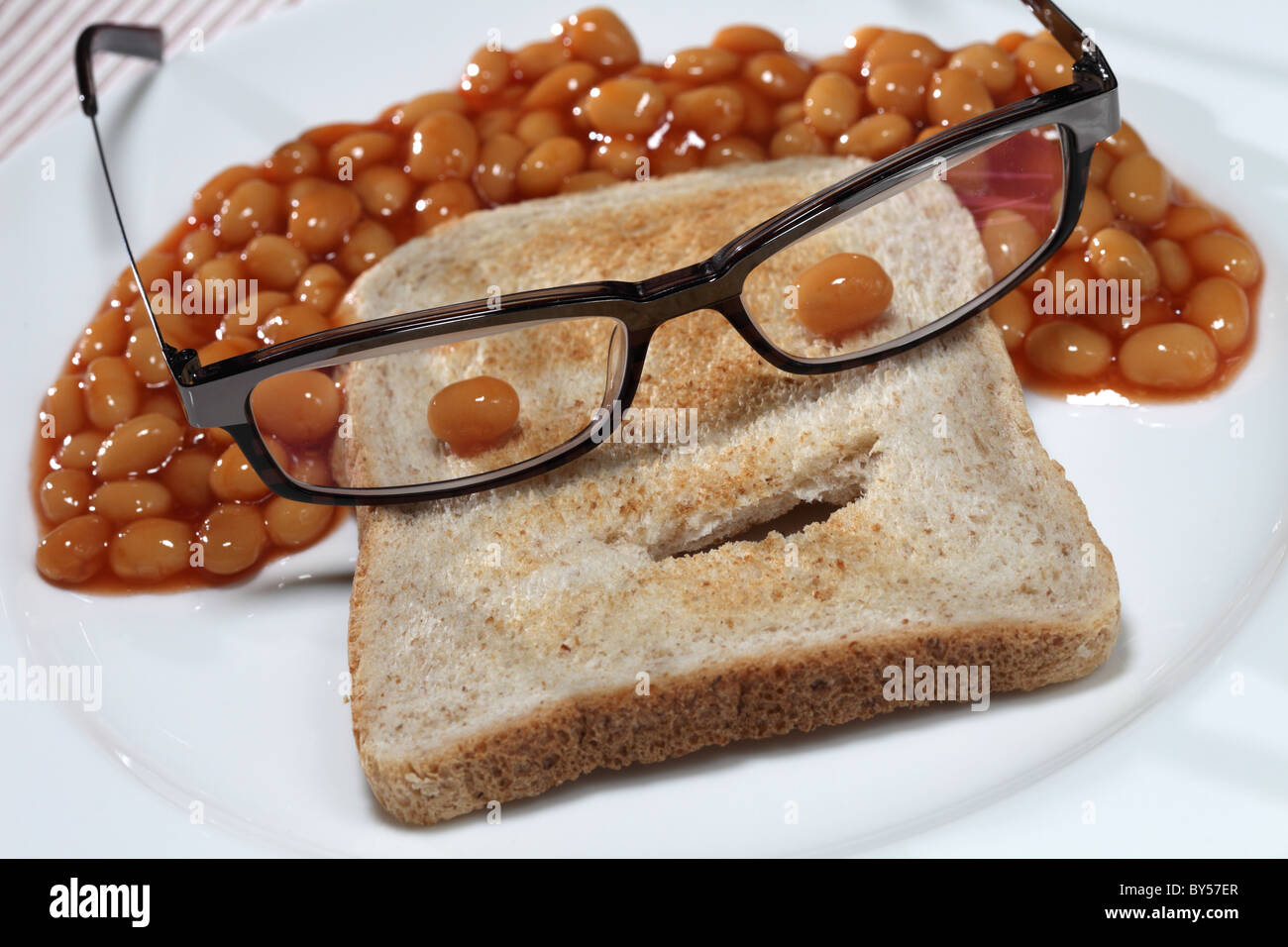 gebackene Bohnen Toast Brot lustiges Gesicht Gläser Stockfoto